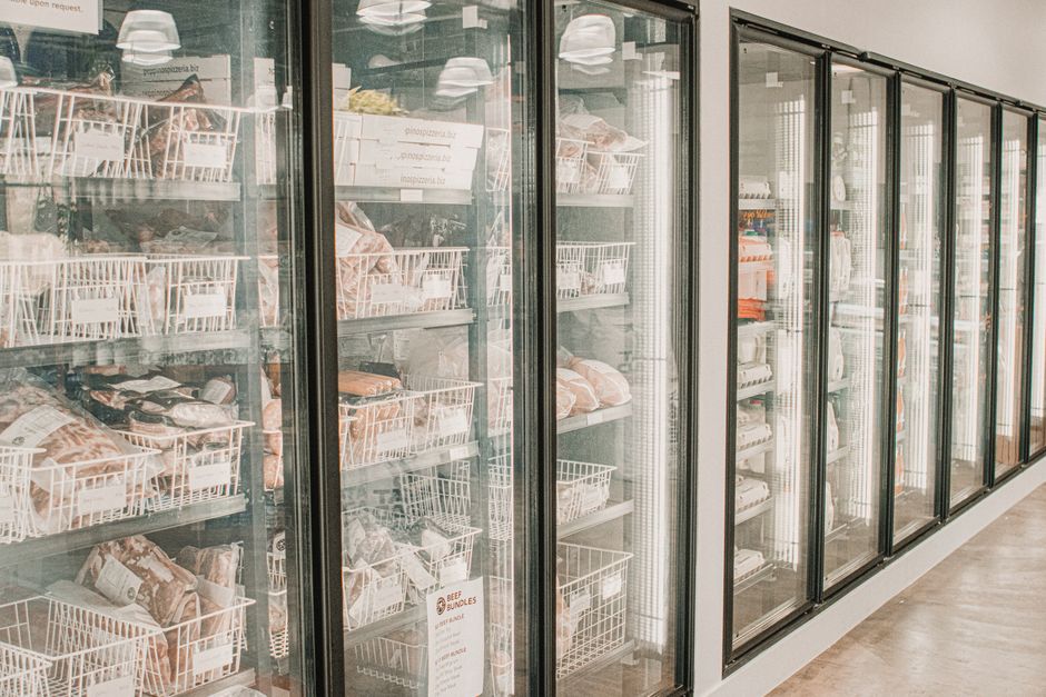 Een moderne koeltoonbank in een restaurant met vers voedsel en drank.